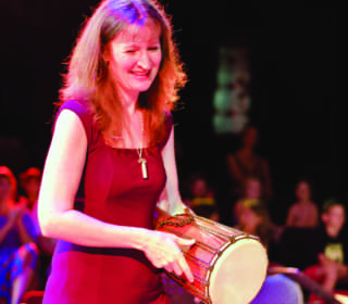 Imogen Wolf playing percussion during WolfSong choir concert at Byron Bay Theatre
