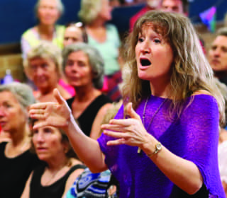 Imogen Wolf conducting SeaSong choir during a performance