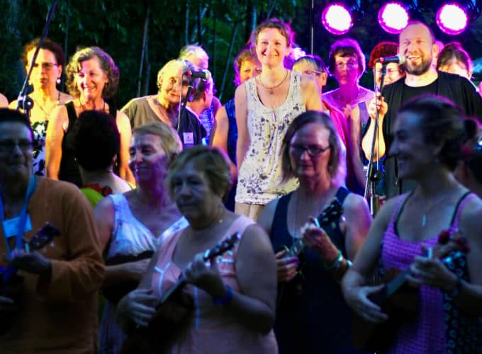 Camp Creative Party In The Park concert with Joy Of Singing choir at the back and ukulele players performing in front